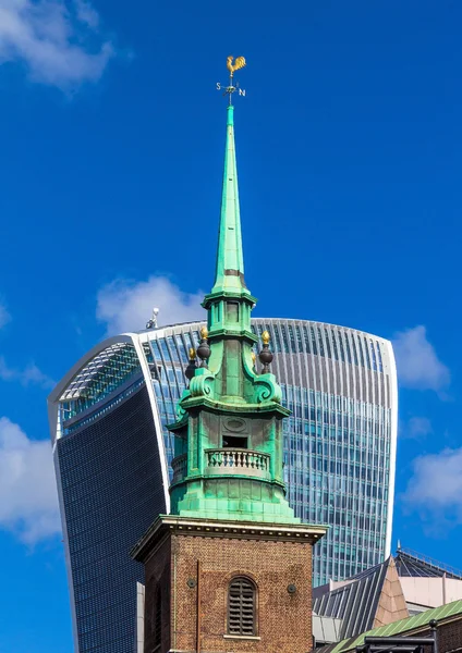 Small church on Trinity Square   on London City with Walkie-Talkie' building  and blue sky background. England