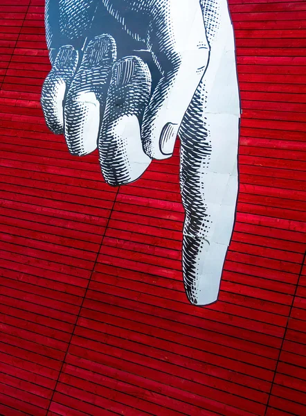 灰色の人差し指下向きの赤い塗られた木製の板の背景に画像左の男の手 — ストック写真