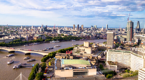 LONDON, UK - JUNE 6, 2015: Aerial cityscape over the river Thames between Haugerford and Waterloo Bridges with tourist pleasure boats in late afternoon time. In the bottom right part of the image visible promenade