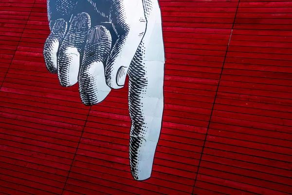 Graues Bild linke Hand des Mannes mit dem Zeigefinger nach unten auf den rot bemalten Holzplanken Hintergrund — Stockfoto
