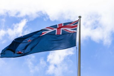 Avustralya bayrağı mavi gökyüzü beyaz bulutlar ile karşı sallayarak