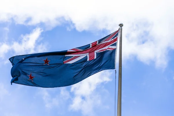 Australian flag waving against a blue sky with white clouds — Stock Photo, Image