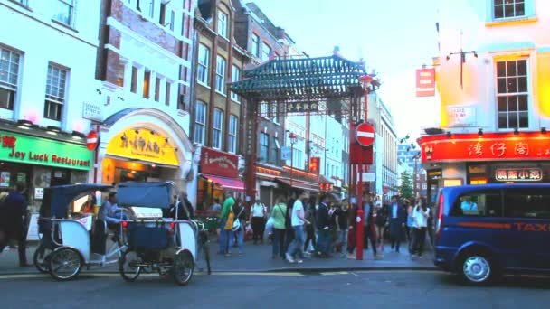 Turistas y lugareños no identificados cerca de la colorida puerta de Chinatown a la hora de la noche — Vídeos de Stock
