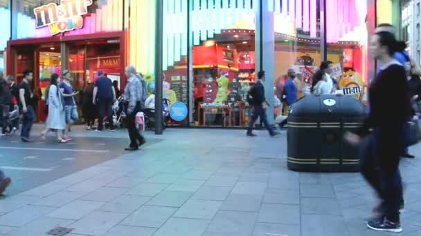 Turistas, lugareños y policías no identificados cerca de colorida tienda grande en Soho — Vídeo de stock