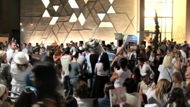 Люди танцуют с библейскими свитками во время церемонии Симхас Торы — стоковое видео