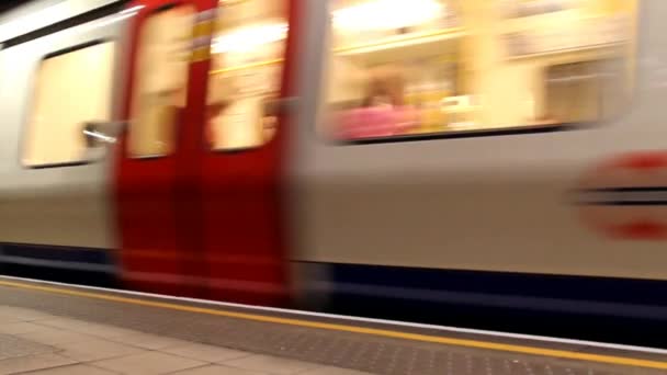 Un train de métro en mouvement arrivant à une station de métro de Londres . — Video