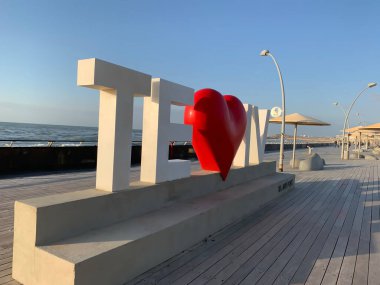 Tel Aviv, İsrail - 3 Mart 2019: Tel Aviv aşk tabelası Mavi gökyüzü ve Akdeniz arka planında