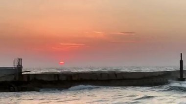 Deniz yüzeyinin altında kızıl güneşli parlak tropikal gün batımı.