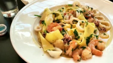 Deniz mahsullü İtalyan makarnası. Karides, küçük ahtapot, kalamar ve kremalı soslu el yapımı erişte. 4K