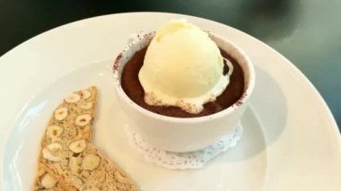 Beyaz fincanda Gateau Petit ve vanilyalı dondurma ve fındıklı bisküvi. 4K