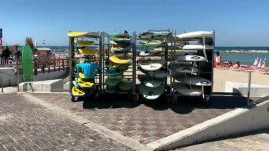 Tel Aviv, İsrail. Akdeniz kıyısındaki metal raflarda ya da raflarda farklı renkte sörf tahtaları. Yerel halk ve turistler için favori ve popüler dinlenme yeri. 4K