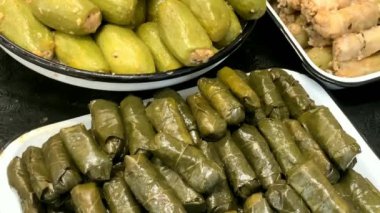 Mağazanın tezgahında farklı oryantal atıştırmalıklar var: doldurulmuş üzüm yaprakları ve kabak. 4K