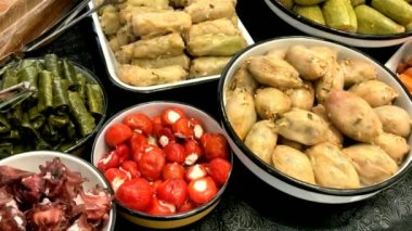 Mağazanın tezgahında farklı oryantal atıştırmalıklar var: doldurulmuş üzüm yaprakları ve kabak. HD