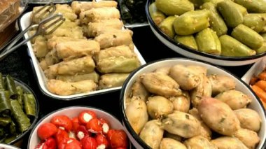 Mağazanın tezgahında farklı oryantal atıştırmalıklar var: doldurulmuş üzüm yaprakları ve kabak. HD