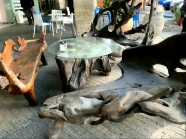 Şehrin sokaklarından birinde ağaç köklerinden yapılmış özel mobilyalar. Kanepeler ve el yapımı masa kökleri, HD