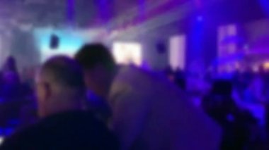 Bir grup siluetli insan (misafirler) düğün resepsiyonu için masalardaki karanlık bir ziyafet salonunda. Bulanık görüş. 4K