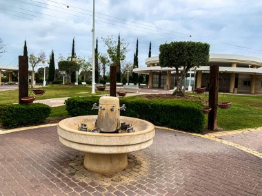 Nahariya, İsrail - 15 Nisan 2019: Mezarlığı ve arka plandaki ayin odasını ziyaret ettikten sonra Yahudi geleneklerine göre el yıkamak için bir su kaynağı