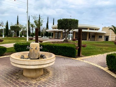 Nahariya, İsrail - 15 Nisan 2019: Mezarlığı ve arka plandaki ayin odasını ziyaret ettikten sonra Yahudi geleneklerine göre el yıkamak için bir su kaynağı