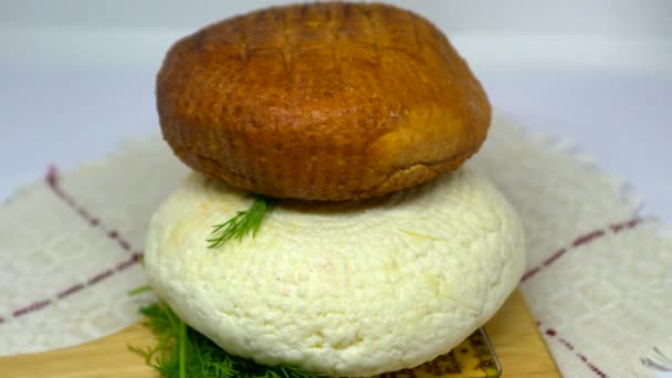 丸みを帯びた柔らかい茶色の燻製と白自家製チーズの異なるタイプ 緑の板の上に横たわっているAdygheチーズ — ストック動画
