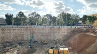 Çok katlı bir binanın inşaatı için çukur. Yeraltı sürekli duvar temeli metodu. Çukurun dibindeki sondaj kulesi. 4K