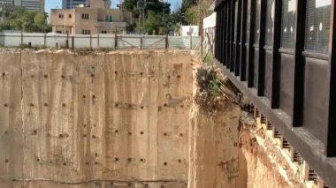 Çok katlı bir binanın inşaatı için çukur. Yeraltı sürekli duvar temeli metodu. Çukurun dibindeki sondaj kulesi. 4K