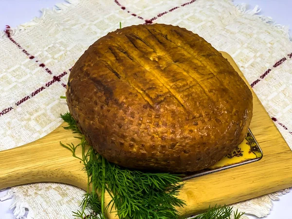 丸みを帯びた柔らかい茶色の自家製チーズ 木の板の上に緑が横たわっているAdygheチーズ — ストック写真