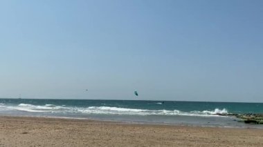 İki uçurtma sörfçüsü deniz dalgalarında süzülür. HD