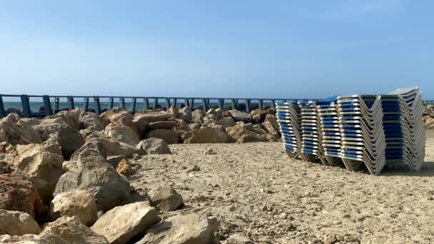 Στοίβα Από Ξαπλώστρες Στην Αμμώδη Παραλία Στο Φόντο Μιας Όχι — Αρχείο Βίντεο