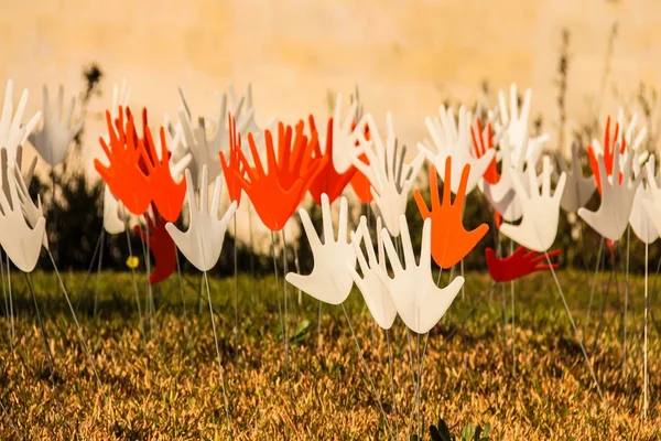 Wiele machając znaki ręce streszczenie lub flagi na trawiasta trawnik — Zdjęcie stockowe