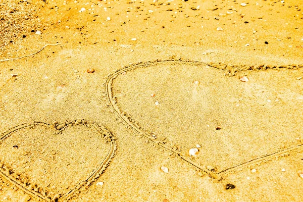 Harten getrokken op het zand strand. — Stockfoto