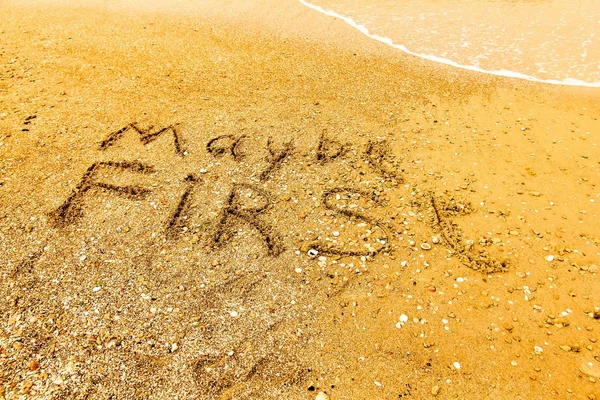 The word MAYBE FIRST written on a sandy beach in bold. — Stock Photo, Image