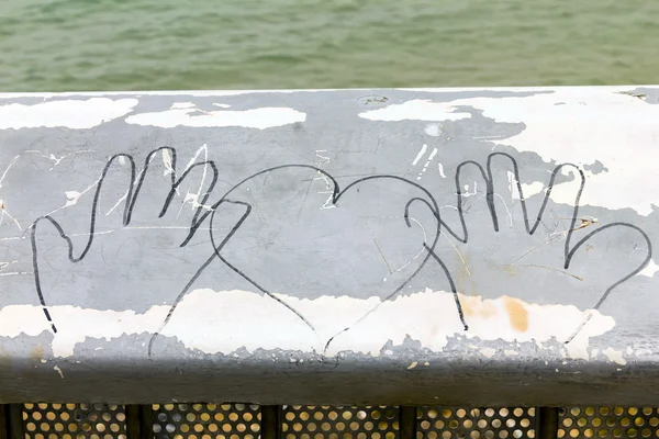 Bild weiblicher und männlicher Hände und Herzen auf der Brüstung der Strandpromenade — Stockfoto