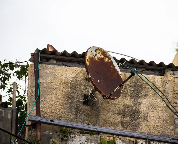Old rusty satellite dish on the  house wall