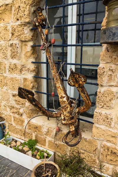 Der alte Metallanker, der an den Gittern am Fenster des Gebäudes befestigt ist — Stockfoto