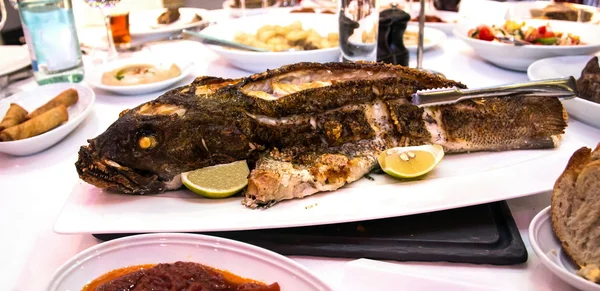 Grouper horneado en el horno en la mesa del banquete —  Fotos de Stock