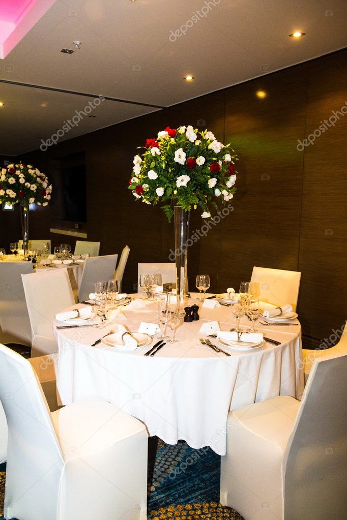 Wedding banquet  hall in shades of white with  beautiful flowers in vases