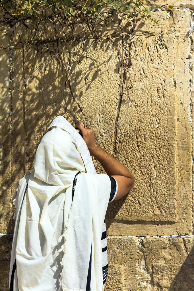 Unidentified jewish worshiper in  tallith  praying at the Wailing Wall an important jewish religious site