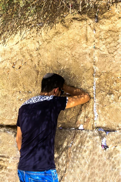 Joven adorador judío no identificado con gorra de calavera rezando en el Muro de los Lamentos un importante sitio religioso judío — Foto de Stock