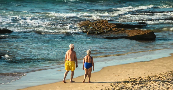 Anziani coppia fa una serata a piedi lungo la riva del mare — Foto Stock