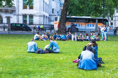 Westminster Abbey yakınındaki çimenlerin üzerinde dinlenme tanımlanamayan turist turist