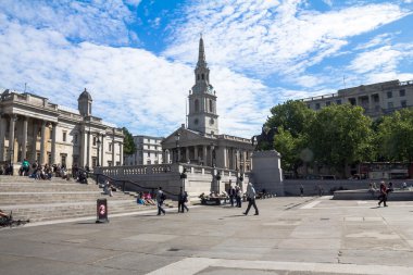 Unidentified  tourists near The church of St Martin's-in-the-Field  and  National Gallery  on Trafalgar Square. . London. UK 