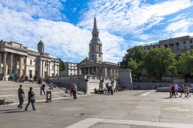 Unidentified  tourists near The church of St Martin's-in-the-Field  and  National Gallery  on Trafalgar Square. . London. UK 