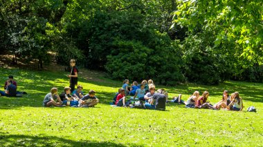 Gençler London St James'ın parkta çim üzerinde dinlenme.