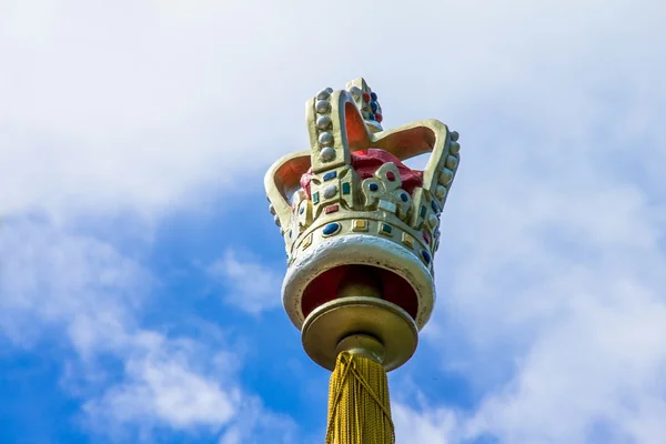 Coroa em cima dos pilares sobre fundo céu azul — Fotografia de Stock