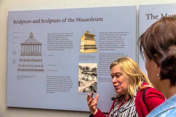 Unbekannter Fremdenführer und Tourist in der Halle mit Marmor aus dem Mausoleum auf halicarnassus. britisches Museum — Stockfoto