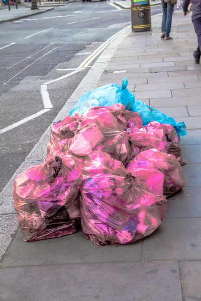 Pembe ve mavi çöp torbaları sokakta — Stok fotoğraf