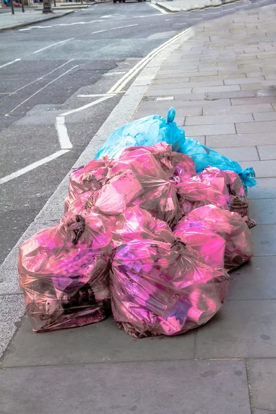 Plast soppåsar på trottoaren — Stockfoto