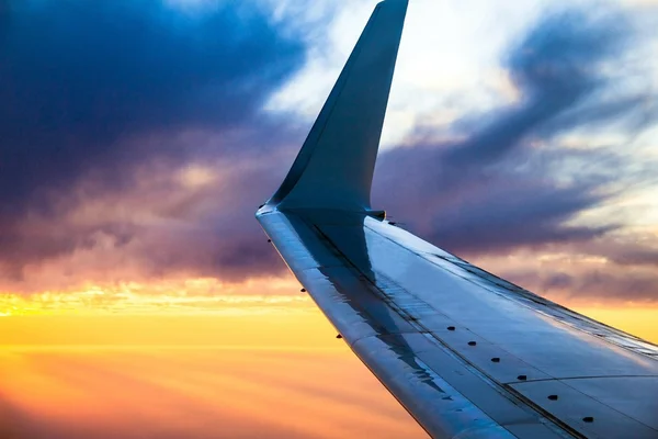 Avión ala al atardecer. Mirando a través de la ventana del avión — Foto de Stock