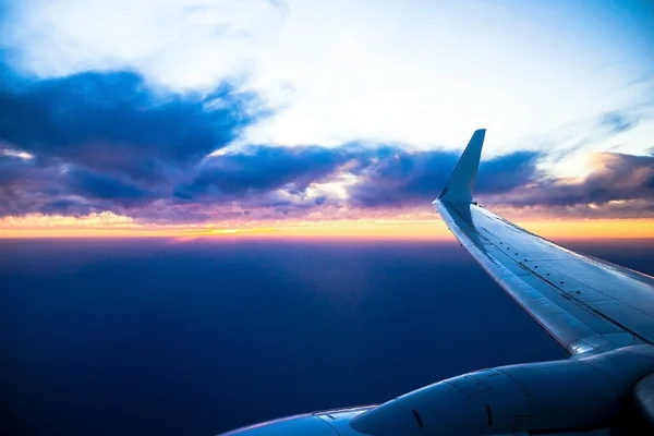 Aviões de asa ao pôr-do-sol. Olhando através da janela do avião — Fotografia de Stock