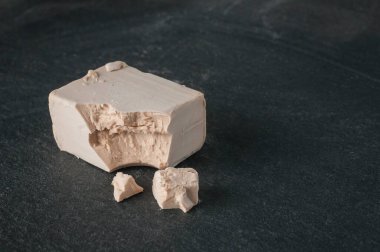 Taze maya çubuğu (bira mayası), ekmek ve pizza doughs için kullanılır, bir kaya kesme tahtasının üzerinde.